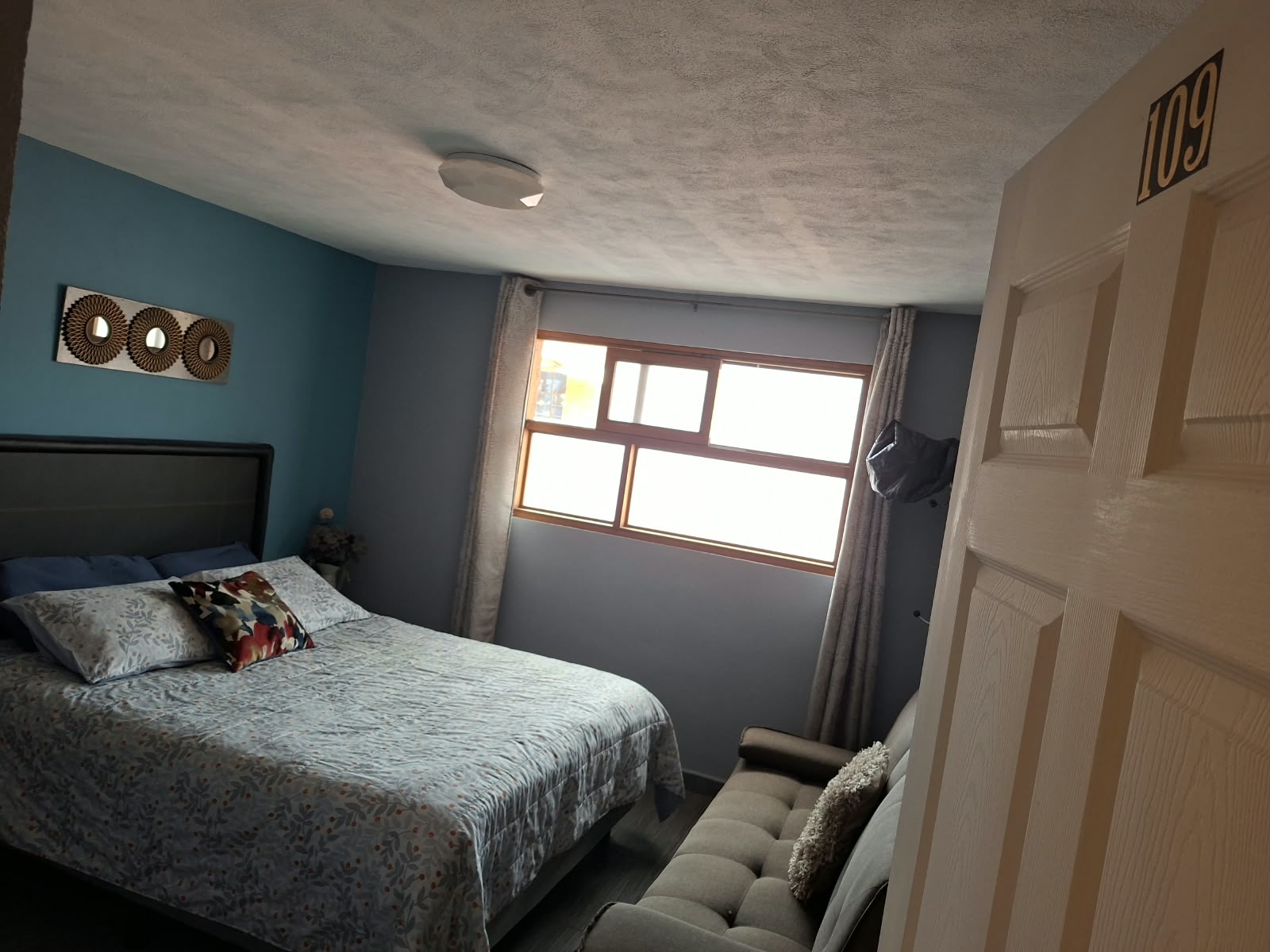 Habitación 109 con cama Queen y número 109 en la entrada